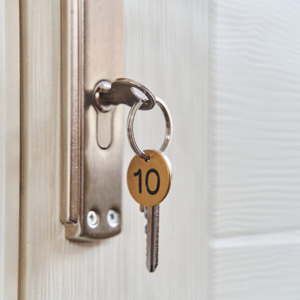 A key with a key fob in the keyhole of the door. Buy a new home concept. Real estate market. High quality photo